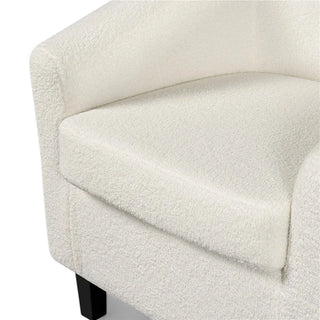 Close-up view of ivory boucle club chair showing the textured fabric upholstery and curved armrest design