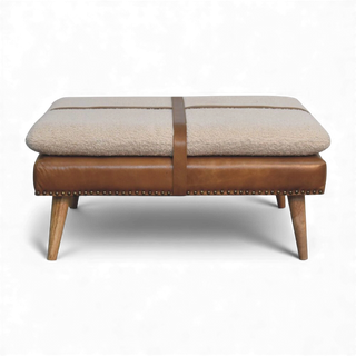 Beige ottoman with brown leather accents on a white background