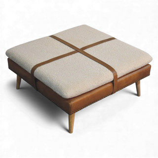 Beige ottoman with brown leather straps on a white background