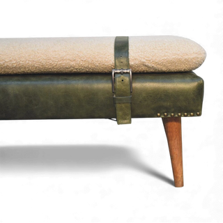Beige cushioned bench with green leather strap and wooden leg on a white background