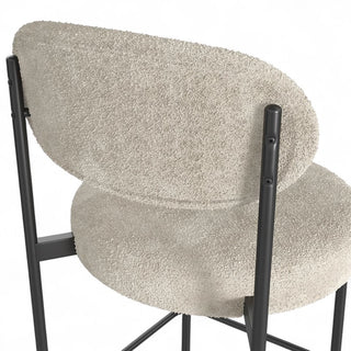 Close-up of Luna Counter Stool back showing curved design and boucle texture against black frame