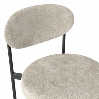 Close-up of Luna Counter Stool's curved back showing cream boucle texture and black frame construction