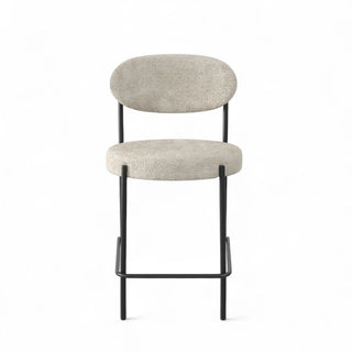Front view of Luna Boucle Counter Stool displaying round seat, curved back, and footrest bar in black metal frame