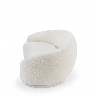 Round white boucle ottoman that complements the curved boucle sofa