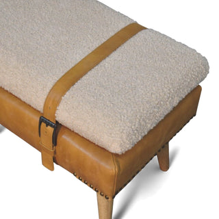 Beige cushioned bench with brown leather straps and buckle on a white background