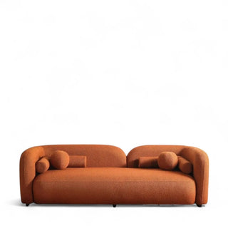 Orange boucle sofa with curved design and round bolster pillows