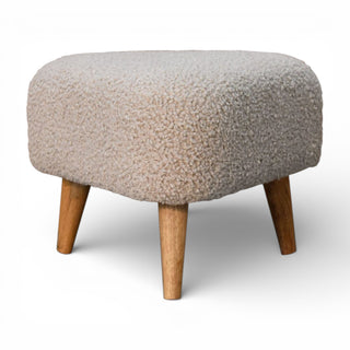 Round ottoman with textured beige cushion and wooden legs on a white background