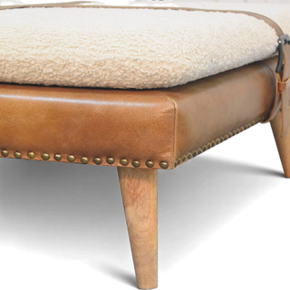 Brown leather ottoman with white cushion on a light gray background