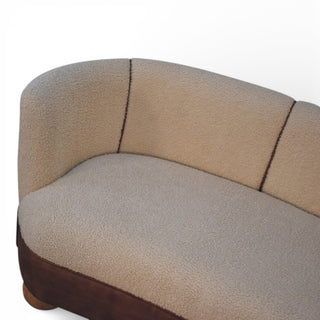 Close-up of a curved piece of furniture with beige and brown upholstery on a white background