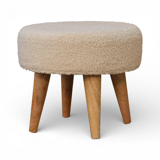 Round ottoman with beige cushioned top and wooden legs on a white background
