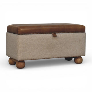 Storage ottoman with brown leather top and wooden legs on a white background