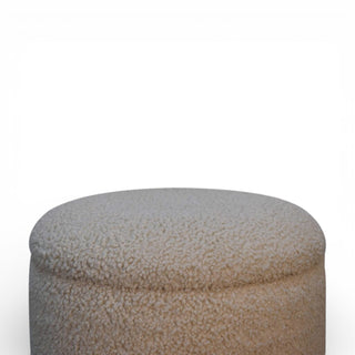 Round beige ottoman with a textured surface on a white background