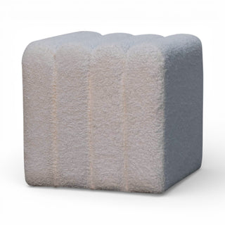 Cube-shaped ottoman with a textured surface on a white background