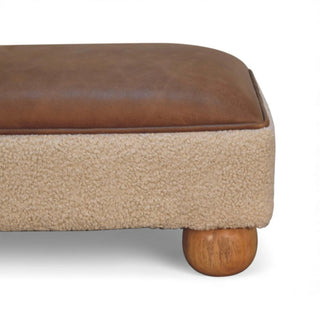 Brown leather and beige fabric ottoman with wooden leg on a white background