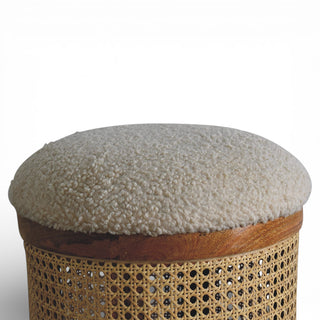 Round ottoman with textured top and woven base on a white background