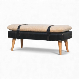 Beige cushioned bench with black leather straps and wooden legs on a white background