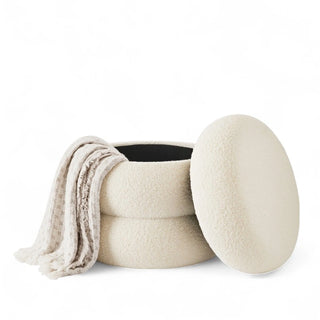 Pebble Ottoman with top removed showing interior storage space with folded blanket
