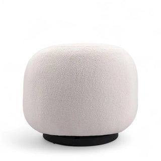 Cream boucle accent chair with rounded cylindrical shape and contrasting black circular base against white background