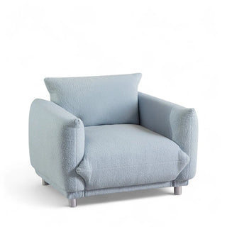 Side angle view of light blue boucle armchair showing arm and seat cushion profile