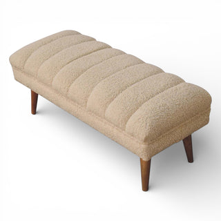 Beige upholstered bench with wooden legs on a white background