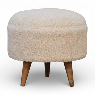 Round ottoman with beige textured top and wooden legs on a white background