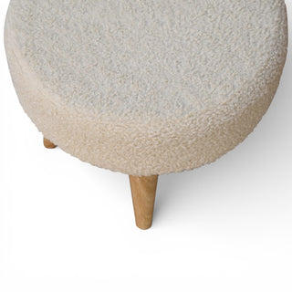 Round ottoman with textured beige cushion and wooden legs on a white background
