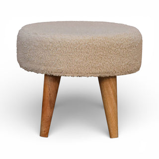 Round ottoman with beige cushioned top and wooden legs on a white background