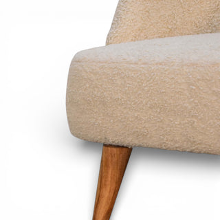Close-up of a beige upholstered chair with wooden legs on a white background