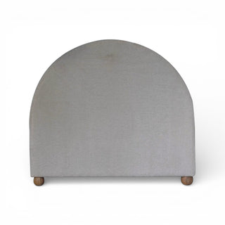 Gray upholstered headboard with wooden legs on a white background
