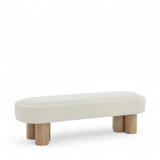 Three-quarter angle view of ivory boucle bench showcasing curved seat edges and cylindrical ash wood legs