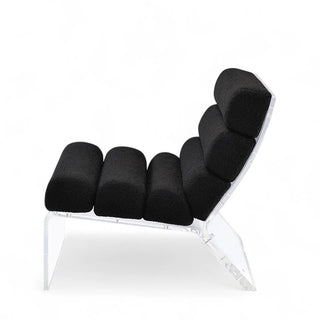 Profile view of black boucle accent chair highlighting floating effect of acrylic frame
