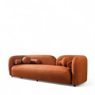 Profile view of orange boucle sofa showing curved silhouette