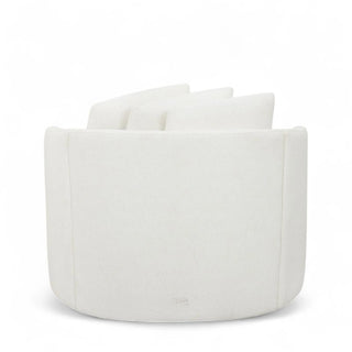 Side profile of white boucle swivel chair showing curved design and thick cushioning