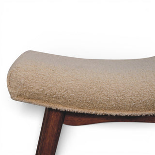 Close-up of a cushioned stool with wooden legs on a white background