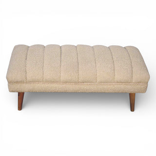 Beige tufted bench with wooden legs on a white background