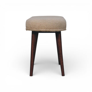 Stool with beige cushioned seat and dark wooden legs on a white background