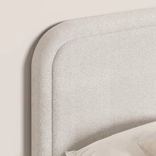Close-up of the rounded corners and curved design of the boucle headboard