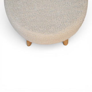 Round ottoman with a textured surface and wooden legs on a white background