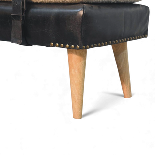 Close-up of a black leather ottoman with wooden legs on a white background