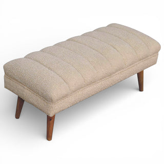 Beige upholstered bench with wooden legs on a white background