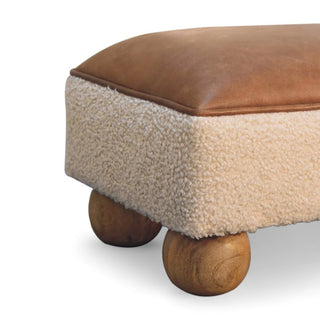 Brown cushioned ottoman with wooden legs on a white background