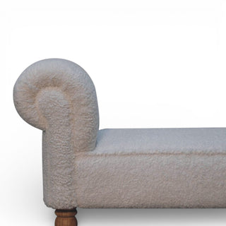 Close-up of a textured sofa corner with wooden legs on a white background