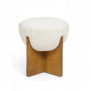 White round boucle ottoman with wooden cross base shown from front angle