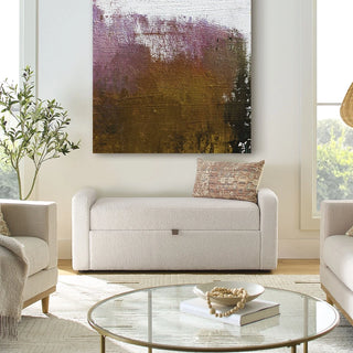White upholstered storage bench placed in living room with glass coffee table and neutral decor