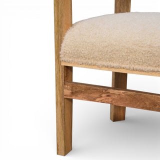 Close-up of a wooden chair with a beige cushion on a white background