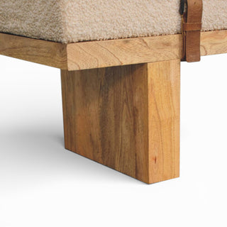 Close-up of a wooden furniture leg with a beige cushioned seat