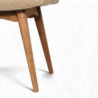 Close-up of the Bouclé Bench Cream Curved Nordic focusing on the angled wooden legs and edge of the curved seat.

