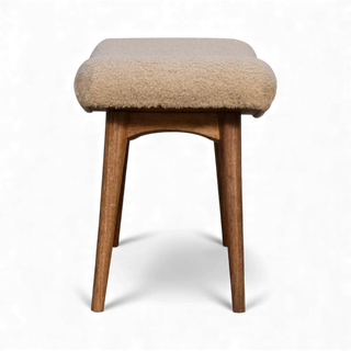 Side view of the Bouclé Bench Cream Curved Nordic showing the curved seat profile and splayed wooden legs.