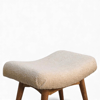 Three-quarter angled view of the Bouclé Bench Cream Curved Nordic from the left side showing the full seat and legs.

