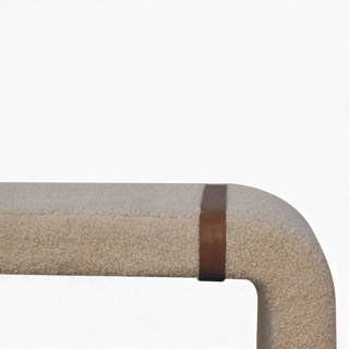 Three-quarter angled view of the Bouclé Bench Cream Leather Strap from the right side showing the curved legs and leather strap accents.

